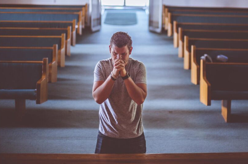 man kneeling in church praying scaled2