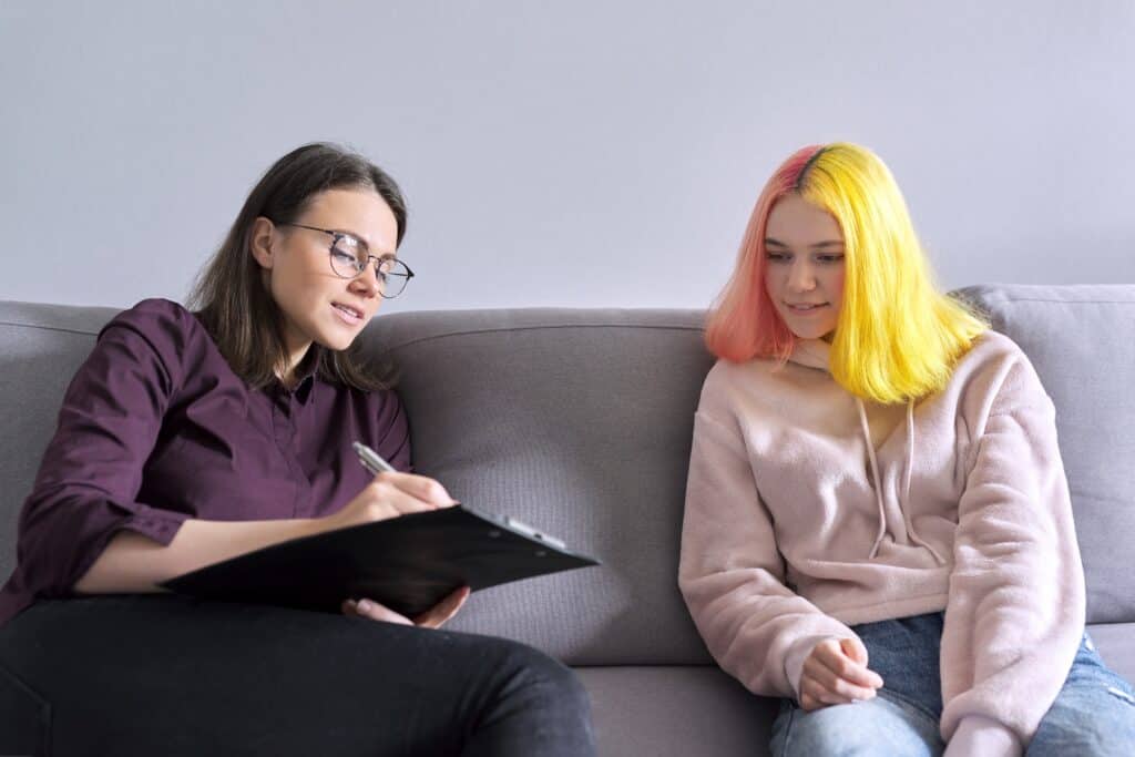 woman psychologist working with teen girl visit and counseling of professional therapist